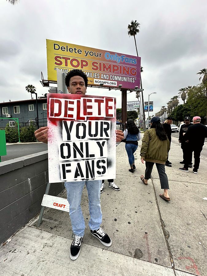 Marcher holding a hand-stencilled Delete Your OnlyFans sign