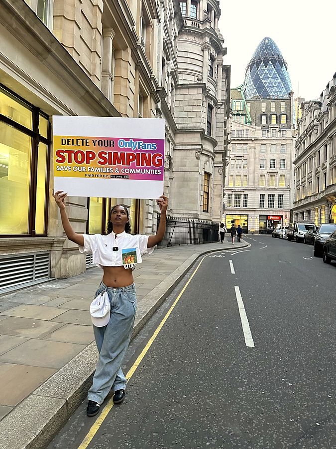 Marcher holding the Stop Simping poster on Bishopsgate, London