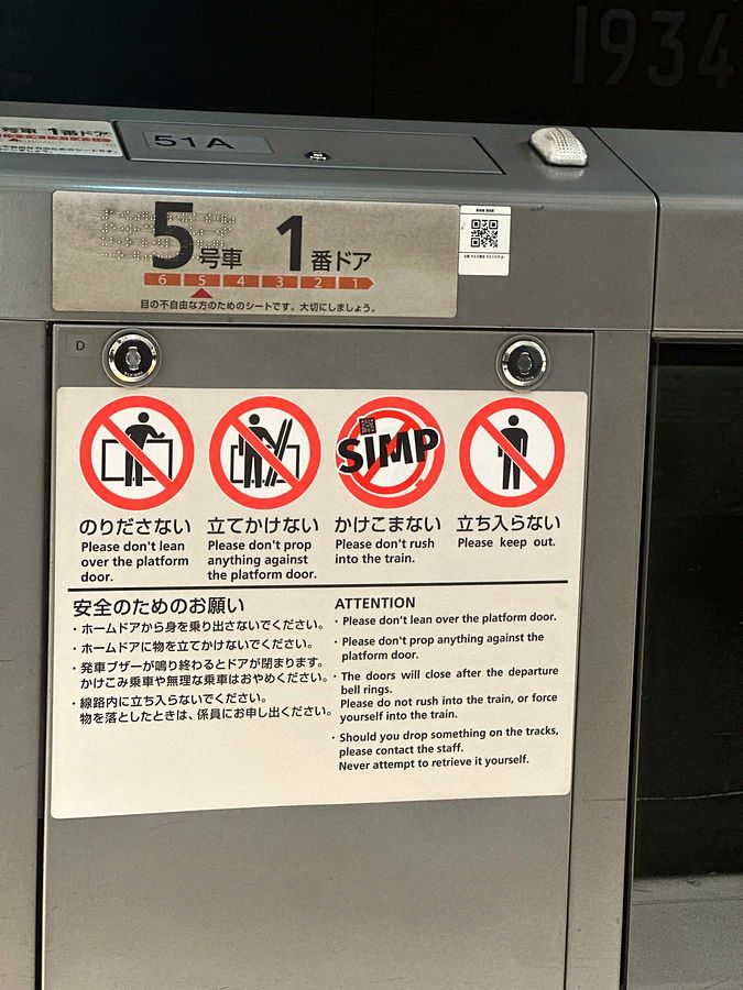 A NO SIMP sticker placed among the prohibition pictograms on a Tokyo platform door