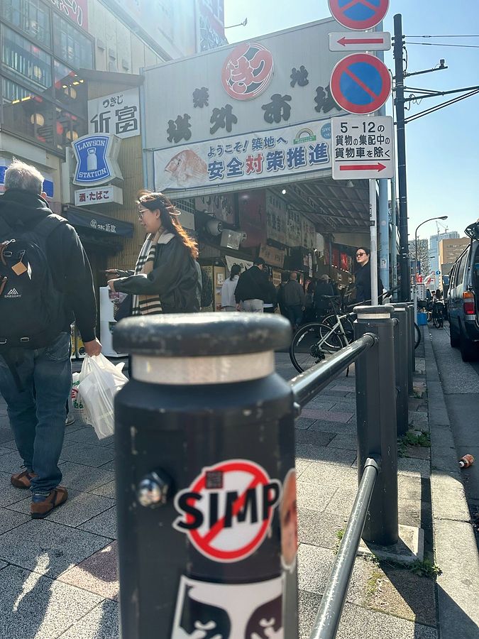 A NO SIMP sticker on a bollard outside Tsukiji market