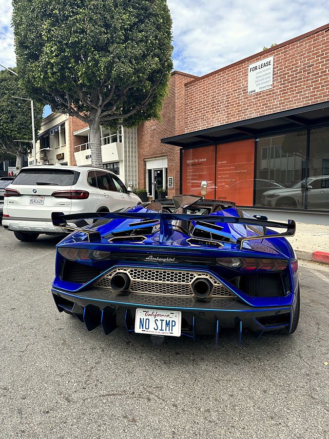 A blue Lamborghini with a California NO SIMP license plate