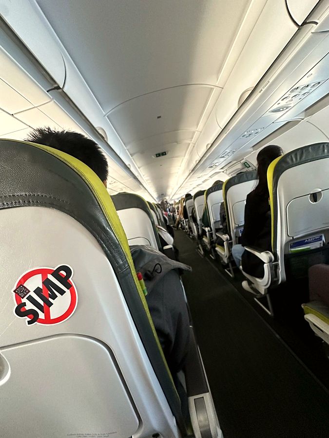 A NO SIMP sticker on an airplane seat back